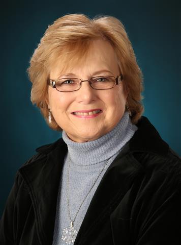 Older female with short blond hair and glasses